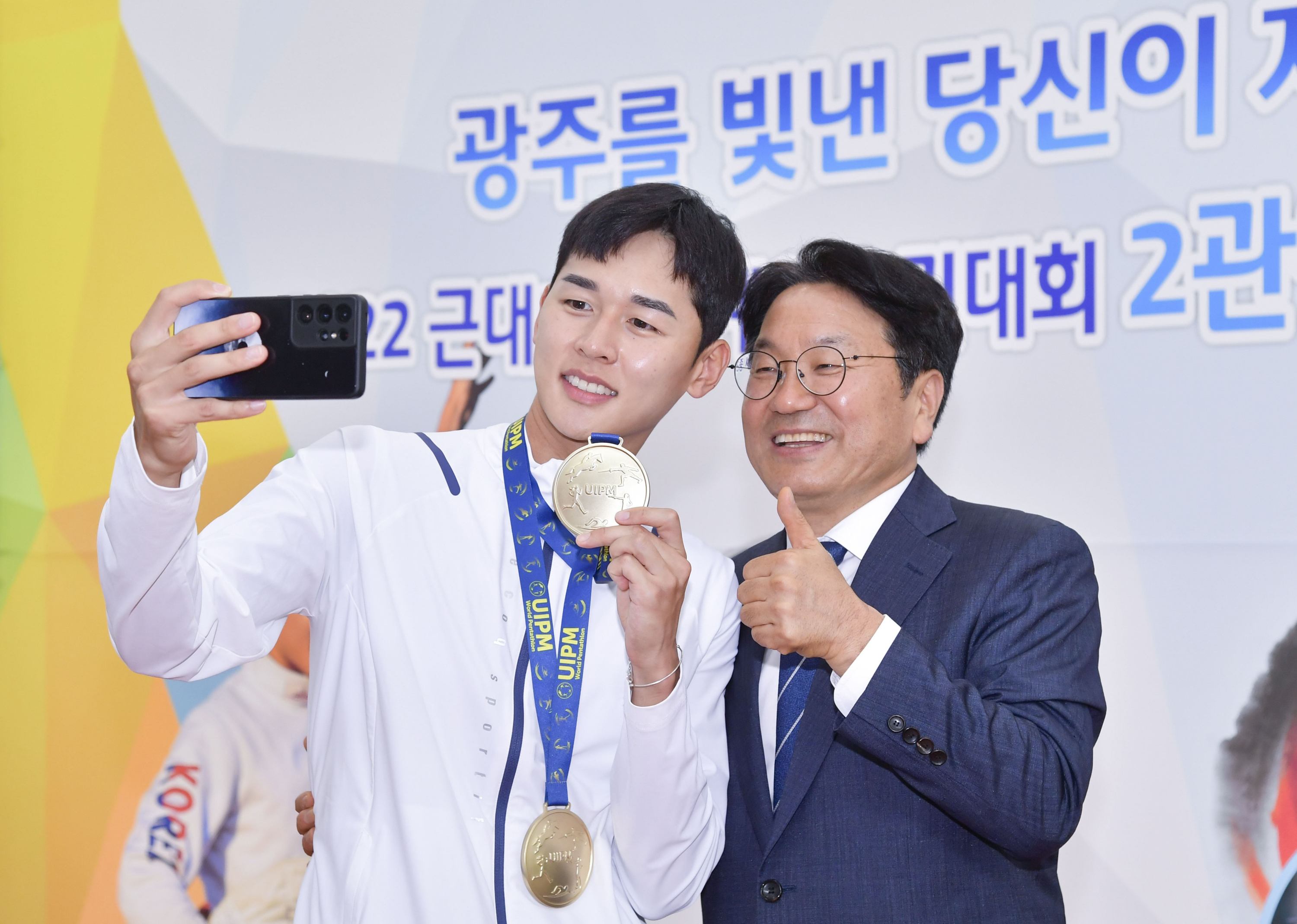강기정 광주광역시장이 지난 2022년 8월 8일 오전 시청 시민홀에서 열린 ‘2022 근대5종 세계선수권대회 2관왕 전웅태 선수 환영식’에 참석해 전웅태 선수와 셀카를 촬영하고 있다./광주광역시 제공